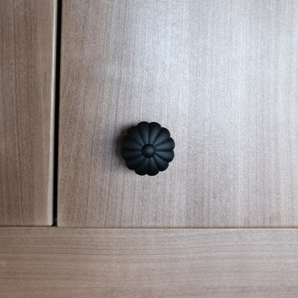 Matte Black Flower Knob on Wood Kitchen Cabinets.